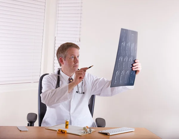 Doctor pointing pen at x-ray chart — Stock Photo, Image