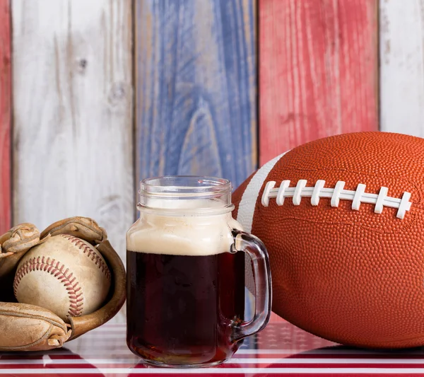 Cerveza y objetos deportivos americanos con tablas de madera descoloridas pintan —  Fotos de Stock