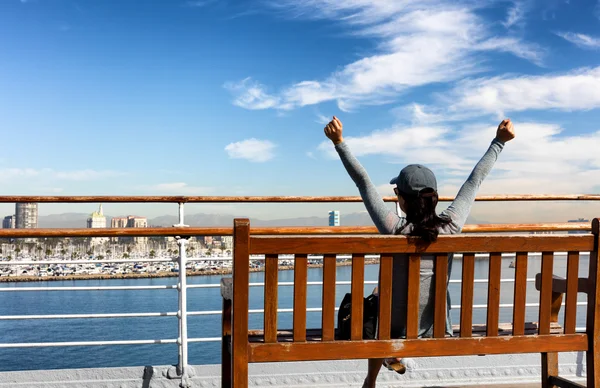 ベンチに伸ばしながら湾の景色を楽しむ女性 — ストック写真