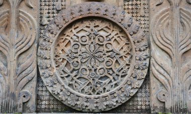 Geleneksel iç içe geçmiş motifler ve çiçek süslemeleri içeren entrika oyulmuş Ermeni kilise taşı madalyonu