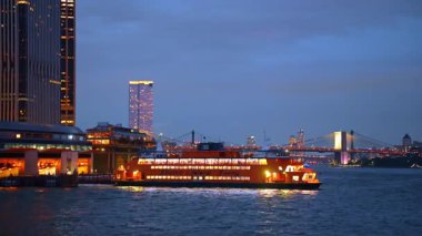 New York, ABD, 1 Ağustos 2025: Staten Island Feribotu gece parlıyordu. Parlak ışıklı Staten Island Feribotu New York City silueti ile nehri geçiyor..