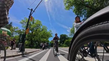 New York, ABD, 1 Ağustos 2025: Central Park 'ta karşıdan karşıya geçen bisikletçiler. Bisikletçiler ve yayalar güneşli bir günde Central Park 'ta karşıdan karşıya geçiyorlar..