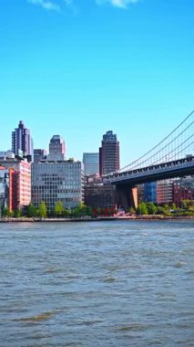 New York, East River üzerindeki Manhattan Köprüsü. Manhattan Köprüsü, New York şehrinin arka planında şehir binalarıyla Doğu Nehri üzerinde uzanır..