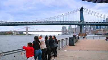New York, ABD, 1 Ağustos 2025 Brooklyn ve Manhattan Köprüleri 'nde insanlar rıhtımdan izliyor. İnsanlar New York 'taki Brooklyn Köprüsü ve Manhattan Köprüsü' ne bakan bir rıhtımda duruyor..