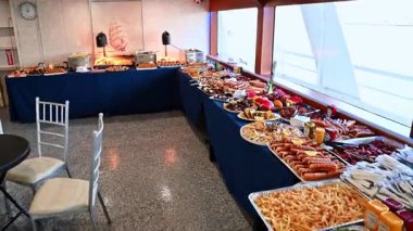 New York, ABD, 1 Ağustos 2025: Taco ve tatlılarla dolu gemi gurmesi gezisi. Okyanus manzaralı bir yolcu gemisinin yemek masasında çeşitli taco, meyve ve tatlılar..