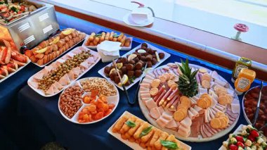 Açık büfe masasında çeşitli soğuk mezeler ve etler. Et, peynir, kraker, kanat ve renkli salatalarla dolu güzel bir açık büfe düzenlemesi..