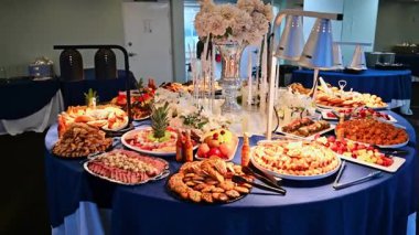 New York, ABD, 1 Ağustos 2025: Zarif yolcu gemisi büfesi gurme yemekleri ve çiçeklerle süslenmiş. Zarif çiçek düzenlemeleri ve gurme atıştırmalıkları olan bir yolcu gemisinde lüks bir ziyafet masası..