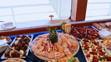 New York, ABD, 1 Ağustos 2025: Et, peynir ve meyve tabakları ile şık bir büfe. Konuklar için hazırlanmış jambon, kanat, sosisli ve taze meyve tabakları olan lüks büfe masası..