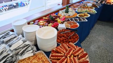 New York, ABD, 1 Ağustos 2025: Yolcu gemisinde çeşitli tabaklar bulunan uzun büfe masası. Etler, salatalar, sosisliler ve yolcu gemisinde servis edilen tatlılarla dolu geniş bir büfe..