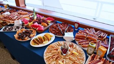 New York, ABD, 1 Ağustos 2025: Çeşitli yiyeceklerle dolu bir yolcu gemisinde uzun bir açık büfe masası. Yolcu gemisi restoranında çeşitli gurme yemekleri, meyveler ve tatlılarla dolu geniş bir açık büfe masası..