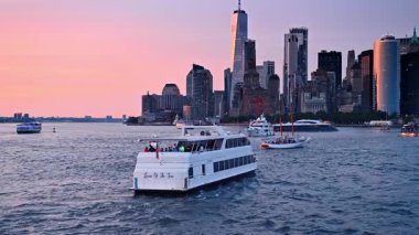 New York, ABD, 3 Ağustos 2025, Manhattan yakınlarında gün batımında tekne gezintisi. Hudson Nehri boyunca yelken açan tekne ve yatlar. Gün batımında parlayan Manhattan silueti.