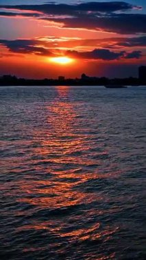 Hudson Nehri üzerinde gün batımı, New York. Hudson Nehri 'nin üzerinde güzel bir gün batımı New York' un sularında canlı turuncu yansımalarla.