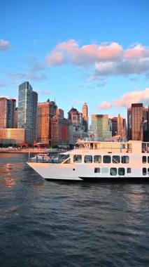 New York, ABD, 3 Ağustos 2025 Manhattan siluetini geçen lüks bir yat. New York şehrinin altın saatinde Manhattan kıyısı yakınlarında süzülen zarif beyaz bir yat..