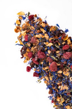 Beyaz arka planda kurutulmuş meyve ve çiçek çayı karışımı. Kurumuş böğürtlen, çiçek yaprakları ve beyaz arkaplanda sıralanmış meyve parçaları ile renkli çay karışımı..