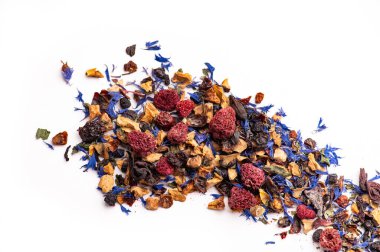 Kurutulmuş böğürtlen ve mavi yapraklarla karışık meyve çayı. Kurumuş ahududu, yaban mersini ve mavi yapraklarla beyaz yüzeye yayılmış renkli meyve çayı karışımı..