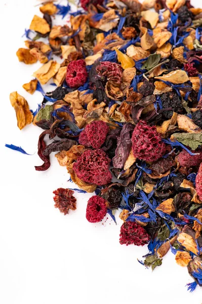 Kurutulmuş böğürtlen ve yapraklı makro fotoğraflı bitki çayı. Kurumuş böğürtlen, çiçek yaprakları ve beyaz arka planda meyve karışımının Macro fotoğrafı..