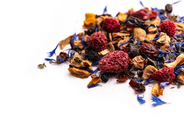 Böğürtlen ve yapraklı makro desenli kurutulmuş bitki çayı. Kurutulmuş bitki çayının makro dokusu ahududu, çiçek yaprakları ve beyaz arka planda otlarla harmanlanmış..