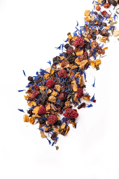 Kurutulmuş böğürtlen ve yapraklı makro manzaralı renkli çay karışımı. Kurumuş ahududu, amber çiçeği ve mavi yapraklı beyaz arka planda renkli çay manzarası.