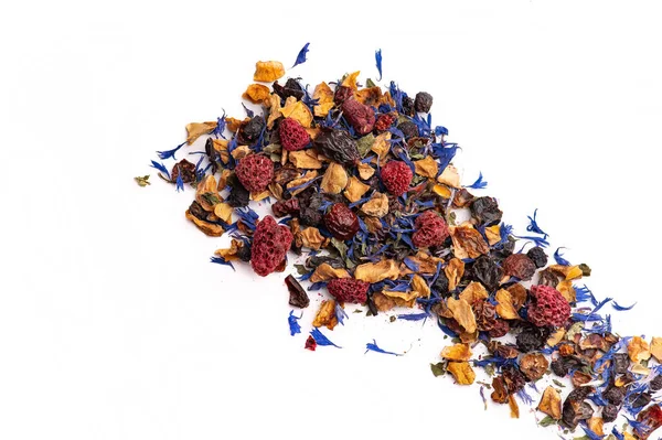 Beyaz arka planda gevşek meyve ve çiçek çayı karışımı. Beyaz arka planda kurumuş ahududu, taç yaprağı ve otlardan oluşan bol yapraklı çay karışımı..