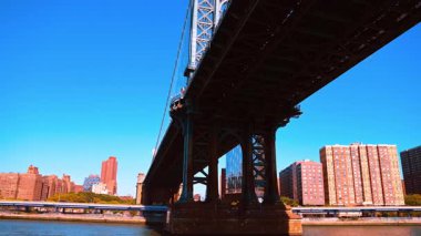 Manhattan Köprüsü perspektifi altında. Manhattan Köprüsü 'nün altından yukarı bakıyor çelik yapıyı ve liman binalarını vurguluyor..