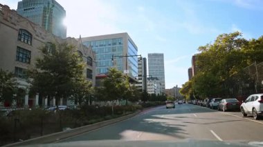 New York, ABD, 9 Ağustos 2025: Manhattan 'da ağaçlar ve trafik olan Sunlit şehir sokağı. Manhattan caddesinde ağaçlar, arabalar ve konut binalarıyla aydınlık güneşli bir gün.