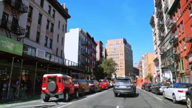 New York, ABD, 8 Ekim 2025: Klasik yangın çıkışları ve hafta sonu trafiği olan SoHo Caddesi, Manhattan. Demirden yangın merdivenleri ve New York, New York 'ta yoğun hafta sonu trafiği olan renkli SoHo bloğu. Kafeler ve dükkanlarla dolu canlı bir şehir manzarası.