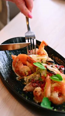 Tabaktaki deniz ürünleri salatasını kapat. Karides ve ahtapot salatası, otlar ve sosla birlikte restoran ortamında..