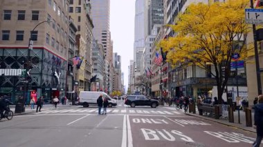 New York, ABD, 8 Kasım 2025: 5. Cadde manzaralı Rockefeller Center. Beşinci Cadde boyunca geniş bir sokak manzarası Rockefeller yakınlarında trafik, dükkanlar ve düşen ağaçları gösteriyor..