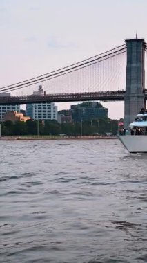 New York, ABD, 8 Ağustos 2025: Nehir üzerindeki Brooklyn Köprüsü 'nün gün batımı manzarası. Sıcak akşam ışığı New York 'taki Brooklyn Köprüsü' nün altındaki suyu yansıtıyor..