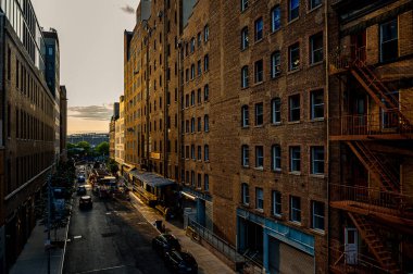New York, ABD, 8 Ağustos 2025, gün batımında tuğla binalar. Sıcak gün batımı ışığı New York 'taki High Line yakınlarındaki tarihi tuğla binaları kaplıyor..