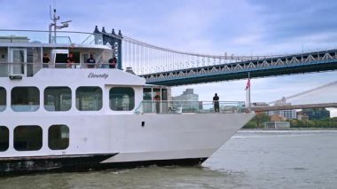 New York, ABD, 8 Kasım 2025: Manhattan Köprüsü yakınlarındaki yolcu gemisi. Akşamki yolcu gemisi sakin sularda Manhattan Köprüsü 'nü geçiyor..