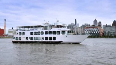 New York, ABD, 8 Kasım 2025: Manhattan Köprüsü yakınlarındaki Eternity yolcu gemisi. Manhattan Köprüsü kıyı şeridinden yükselirken beyaz gemi doğu nehri boyunca ilerliyor.