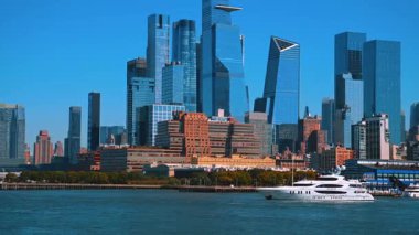 New York, ABD, 1 Kasım 2025 Hudson Nehri üzerindeki Hudson Yards bölge kulesinin modern cam gökdelenleri. Canlı kentsel sahil kenti, ön planda büyük bir yatla birlikte yüksek katlı cam kuleler ve tuğla yapılardan oluşan bir karışıma sahip..
