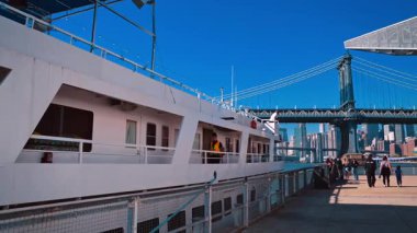 New York, ABD, 5 Aralık 2025: Manhattan Köprüsü ve New York Rıhtımı 'ndaki yolcu gemisi. New York City 'de güneşli bir günde Manhattan Köprüsü' nün yakınına yanaşan büyük beyaz bir yolcu gemisi....