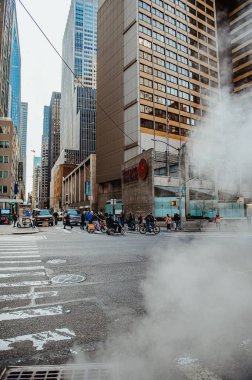 New York, ABD, 9 Aralık 2025, yoğun Midtown Yolu 'nun karşısında. Manhattan caddesinde yükselen buhar yüksek kulelerle dolu..