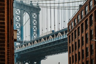 Bulutlu bir günde Brooklyn ve Manhattan Köprüsü manzarası. Brooklyn binaları, bulutlu bir günde Manhattan Köprüsü 'nü bir kamyon geçerken çerçeveletiyor..