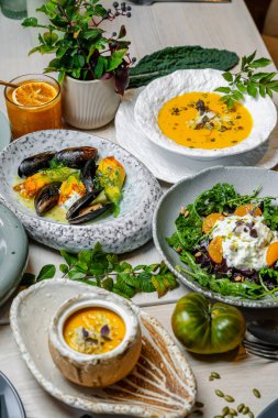 İçkiler ve bitkilerle dolu bir masada birkaç kase yiyecek düzenlenir. İçkiler ve bitkilerle dolu bir masada birkaç kase yemek düzenlenir..