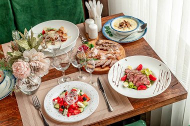 Yemek masasında toplanma etkinliği için çeşitli yemekler ve içecekler hazır. Grup yemeği için çeşitli tabak ve gözlüklerle bir yemek masası düzenlenir..