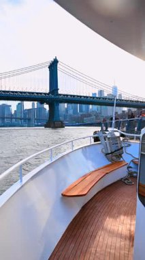 New York, ABD, 24 Ağustos 2025 Manhattan Köprüsü manzaralı tekne güvertesi. Manhattan Köprüsü, ufuk çizgisi olan bir yolcu teknesinden görülen nehri gerer..