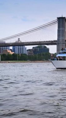 New York, ABD, 24 Ağustos 2025: Brooklyn Köprüsü ve East River 'da yolcu gemisi. Brooklyn Köprüsü ön planda bir yolcu teknesiyle Doğu Nehri 'ni kaplıyor..