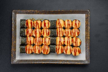 Akşam bir Japon restoranında servis edilecek bir tabakta suşi. Suşi, lezzet için çeşitli soslu çeşitli çeşitleri içeren bir tabakta güzelce düzenlenir..