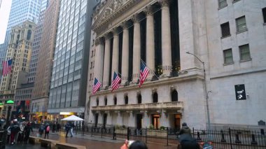 New York, ABD, 25 Aralık 2025: Wall Street 'te New York Borsası binası cephesi. Manhattan 'ın aşağısında Amerikan bayrakları ve Yunan sütunları olan NYSE binasının ön görüntüsü.
