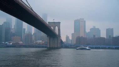 New York, ABD, 25 Aralık 2025: Feribot ile su seviyesinden Brooklyn Köprüsü perspektifi.