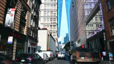 New York, ABD, 5 Ağustos 2025: Manhattan 'daki One World Trade Center' a doğru sokak manzarası. Arka planda modern gökdelen ve trafik olan dar şehir caddesi.