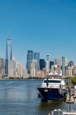 Limanda arkasında gökdelenler olan büyük bir teknenin yakınında..