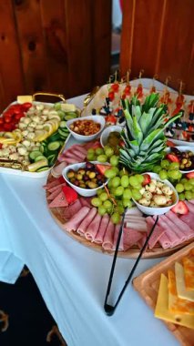 Üzüm ve fındıklı etli ve peynirli şarküteri. Katlanmış jambon, yeşil üzüm ve peynirli yuvarlak ahşap tabaklar.