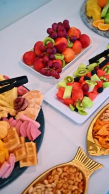 Karpuzlu kivi ve böğürtlenli dilimlenmiş meyve salatası. Karışık meyve parçaları ve siyah servis maşasıyla dikdörtgen beyaz tabak.