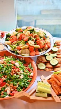 Açık büfe masasında sağlıklı salatalar ve buğulanmış sebzeler. Fındıklı roka salatası ve brokolili havuç karışımı.