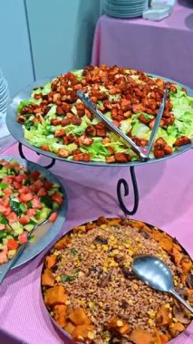 Kızarmış ekmek ve sebzeli taze salata çeşitleri. Kavrulmuş Sezar salatası, salatalık salatası ve metal servis tabağında tatlı patatesli tahıl salatası..