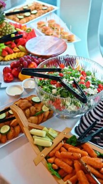 Dilimlenmiş sığır eti ve peynir salatasıyla servis tabağı. Dilimlenmiş biftek, bir kase domates ve feta salatası, ve açık büfedeki peynirli çubuklar..